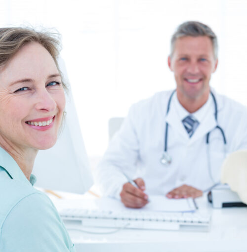 Patient,And,Doctor,Smiling,At,Camera,In,Medical,Office